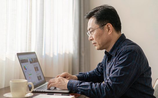 父亲在书桌前用笔记本电脑